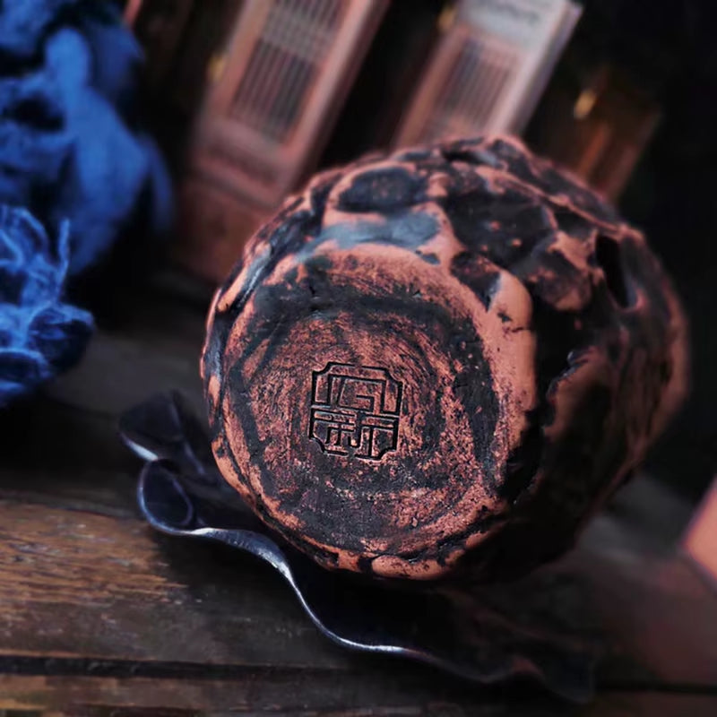 Dark, weathered spherical Xun featuring engraved symbol at center for musical performance