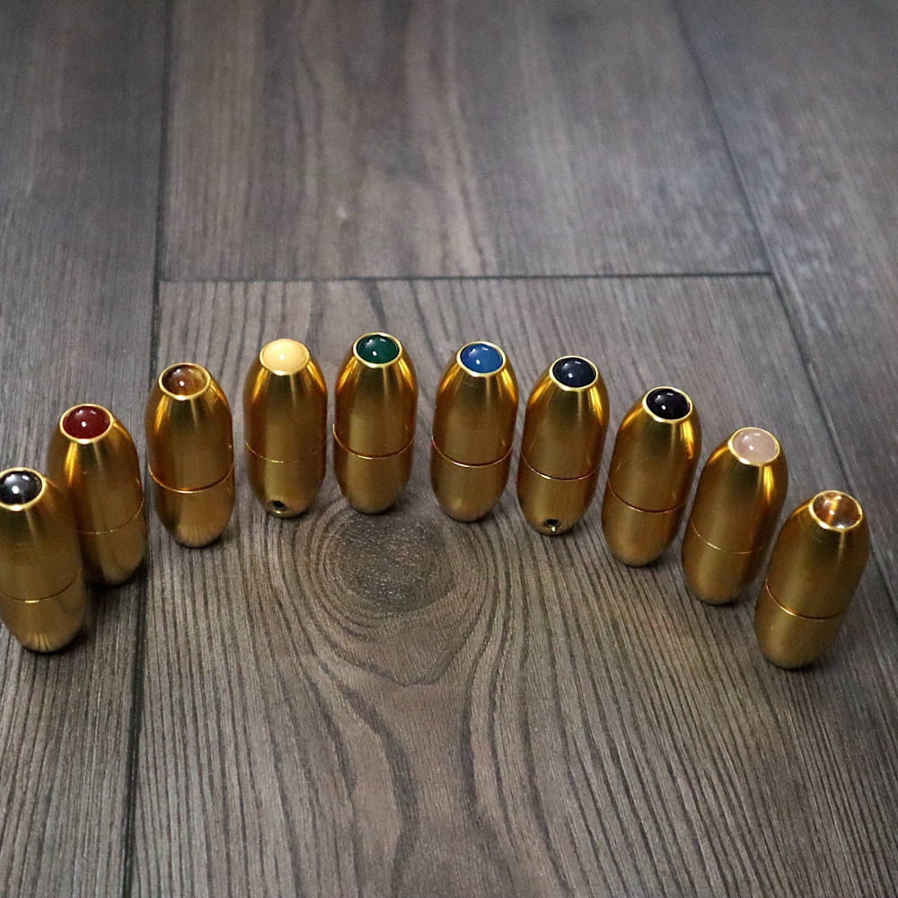Row of gold-colored ammunition cartridges with colored tips in a curved line