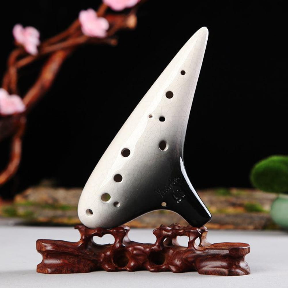 White ceramic ocarina with holes on a brown stand from 12 Hole Tenor Alto C Flute