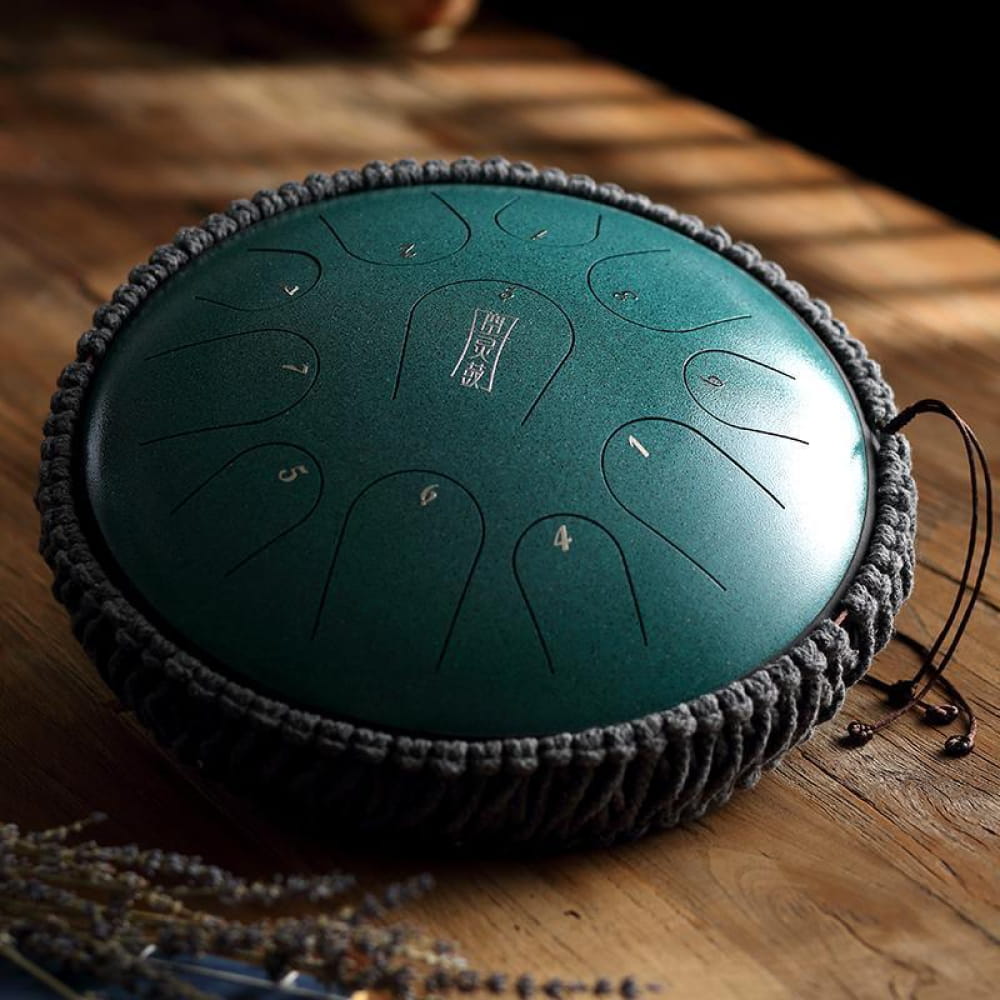 Teal titanium steel tongue drum with black braided border cushion, 11 notes in C Key