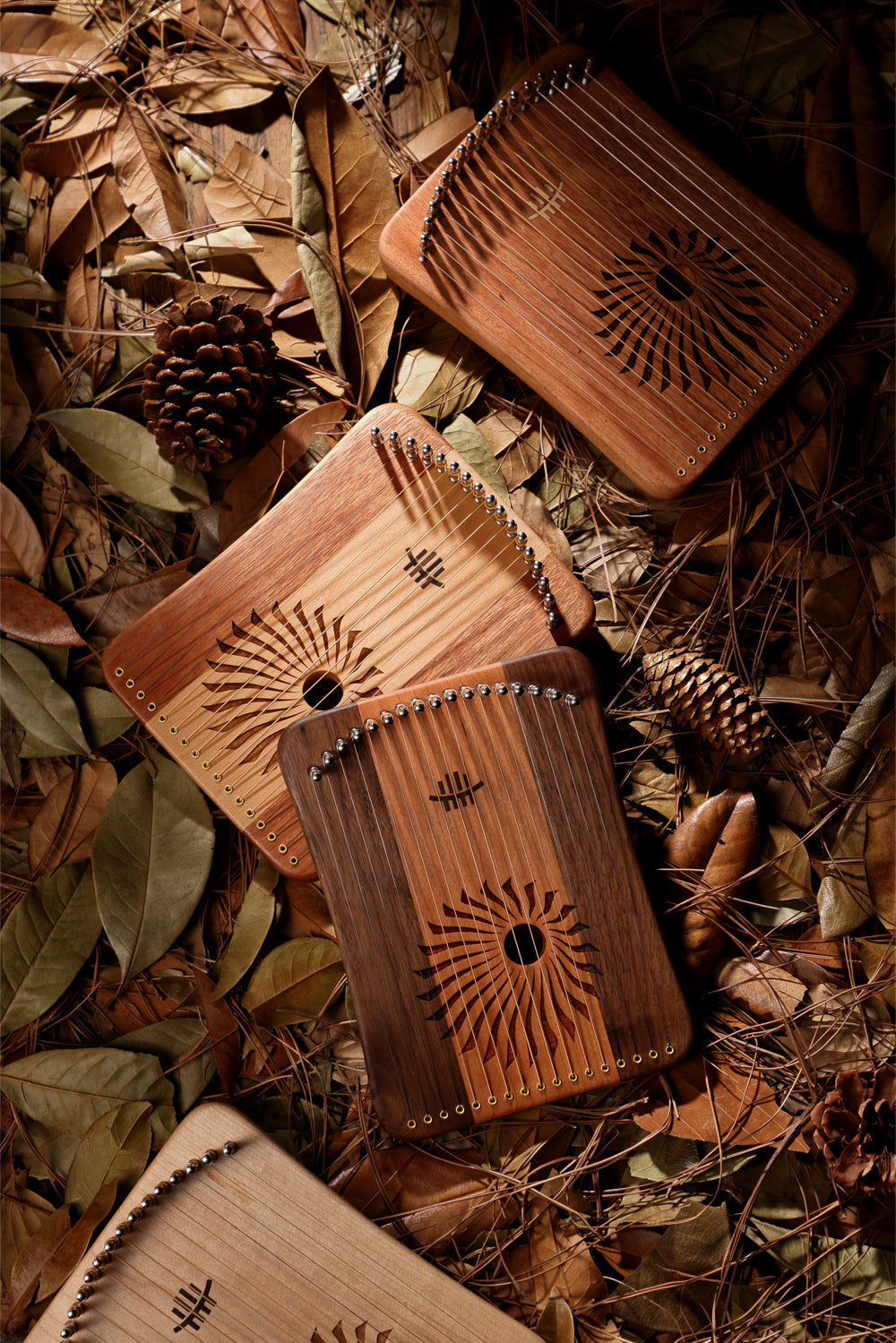 Wooden Kalimbas among autumn leaves and pine cones with Hluru 17/31 String Lyre Harp