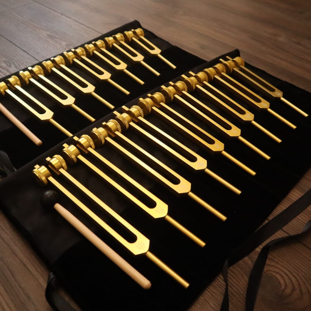 Set of golden tuning forks on black fabric for Solfeggio & Chakra healing