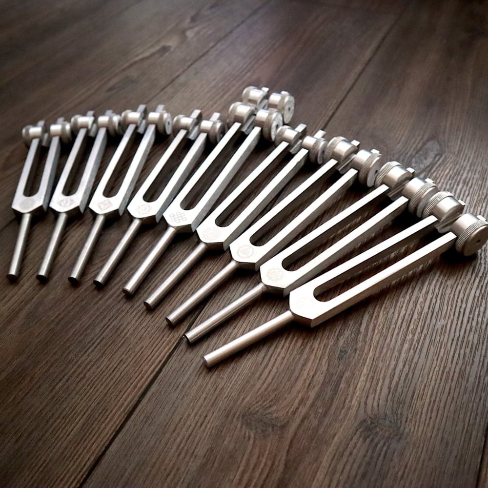 Collection of Solfeggio tuning forks arranged in a curved line for sound healing