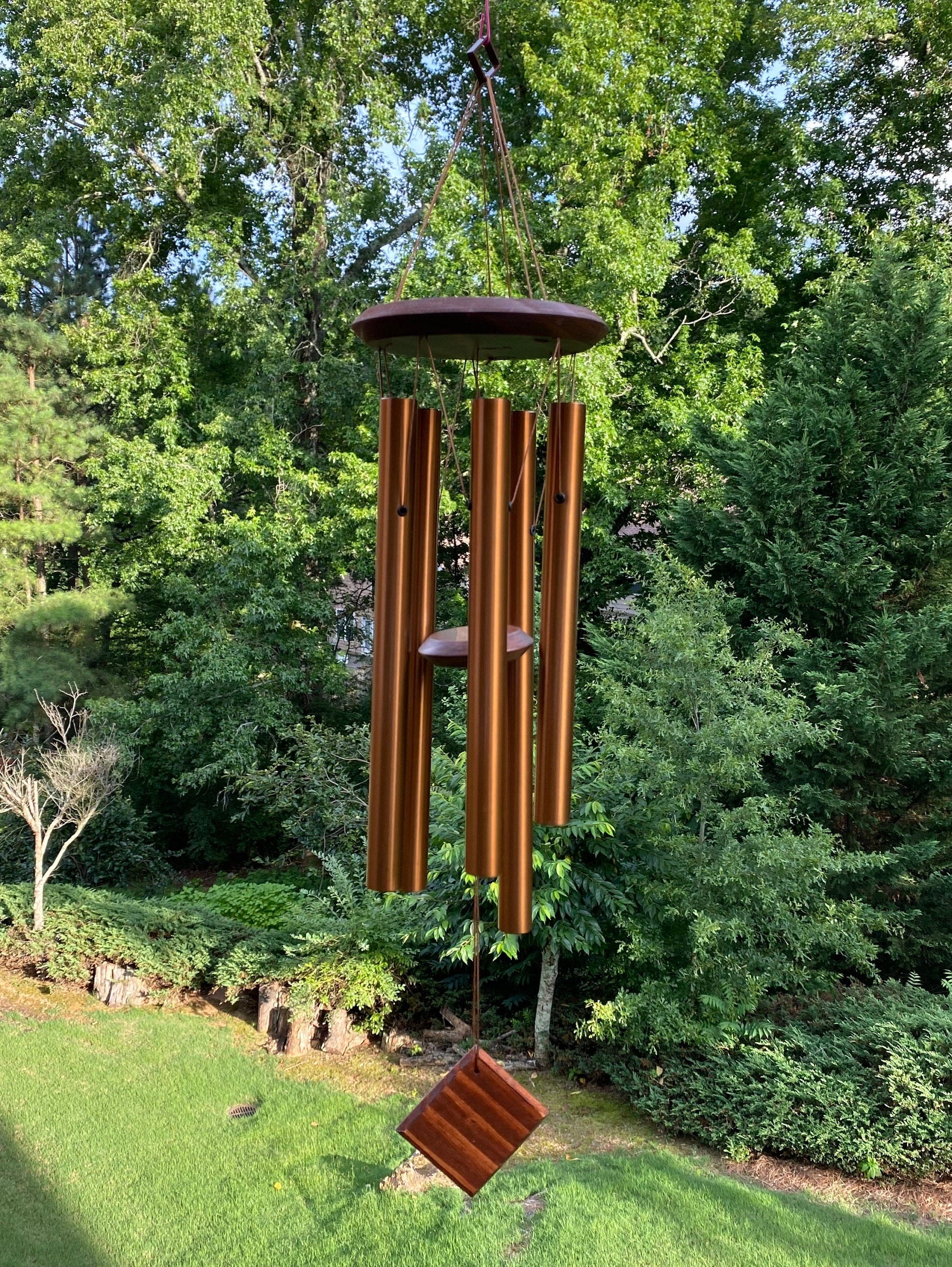 Wooden wind chime with long tubular bells and hexagonal top in golden metal design