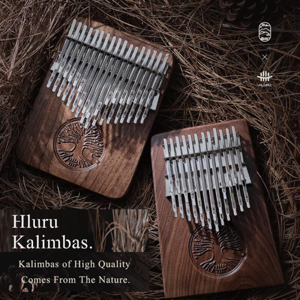 Two wooden kalimbas with metal tines and carved tree designs for meditation use