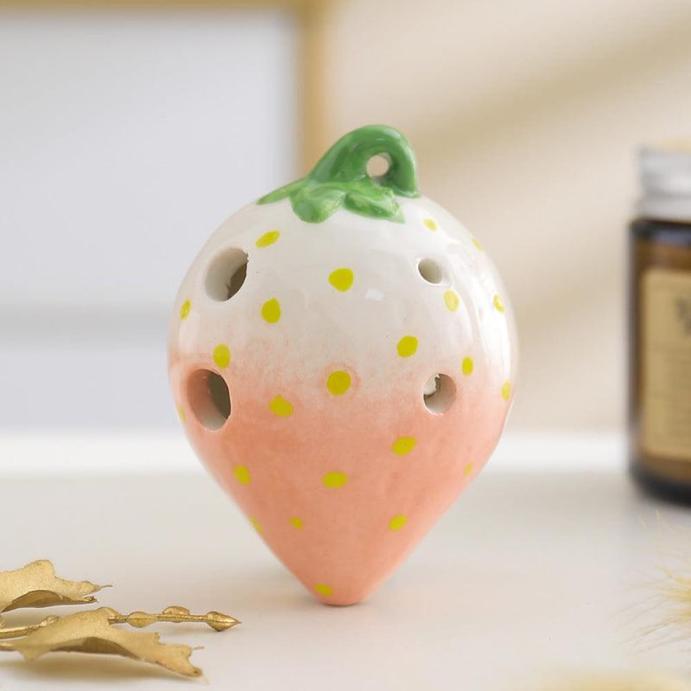 Pink and white ceramic strawberry ocarina pendant with yellow polka dots and green leaf