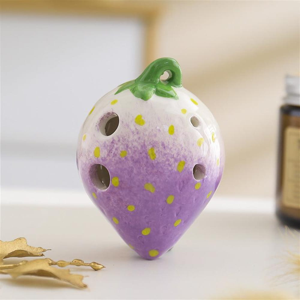 Purple and white ceramic strawberry ocarina pendant with yellow polka dots and green stem