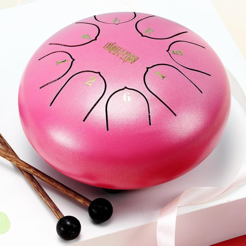 Pink steel tongue drum with black markings and two mallets for beginners and kids