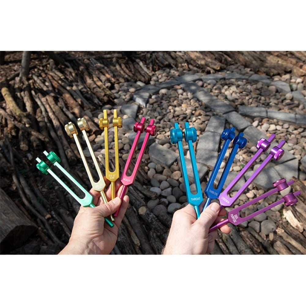 Colorful tuning forks in hands from 8pc Chakra Tuning Fork Set for healing