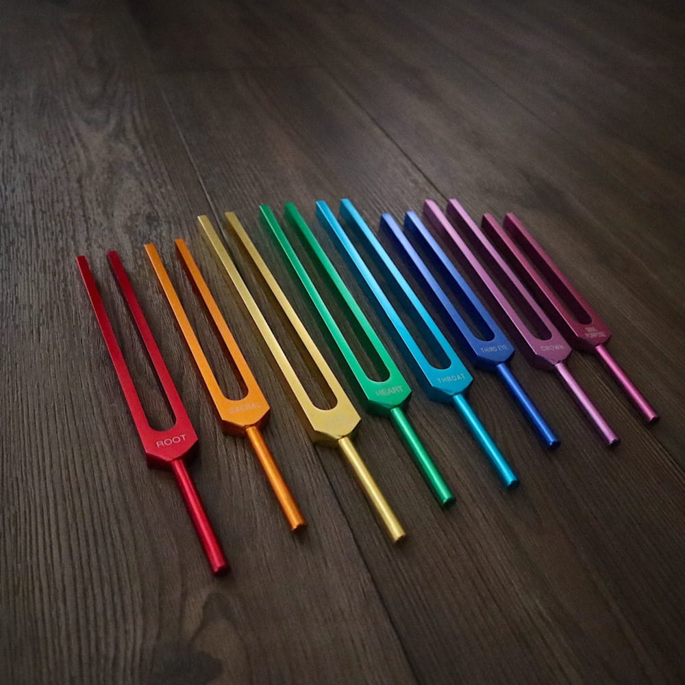 Rainbow-colored tuning forks in a row for chakra healing and biofield therapy