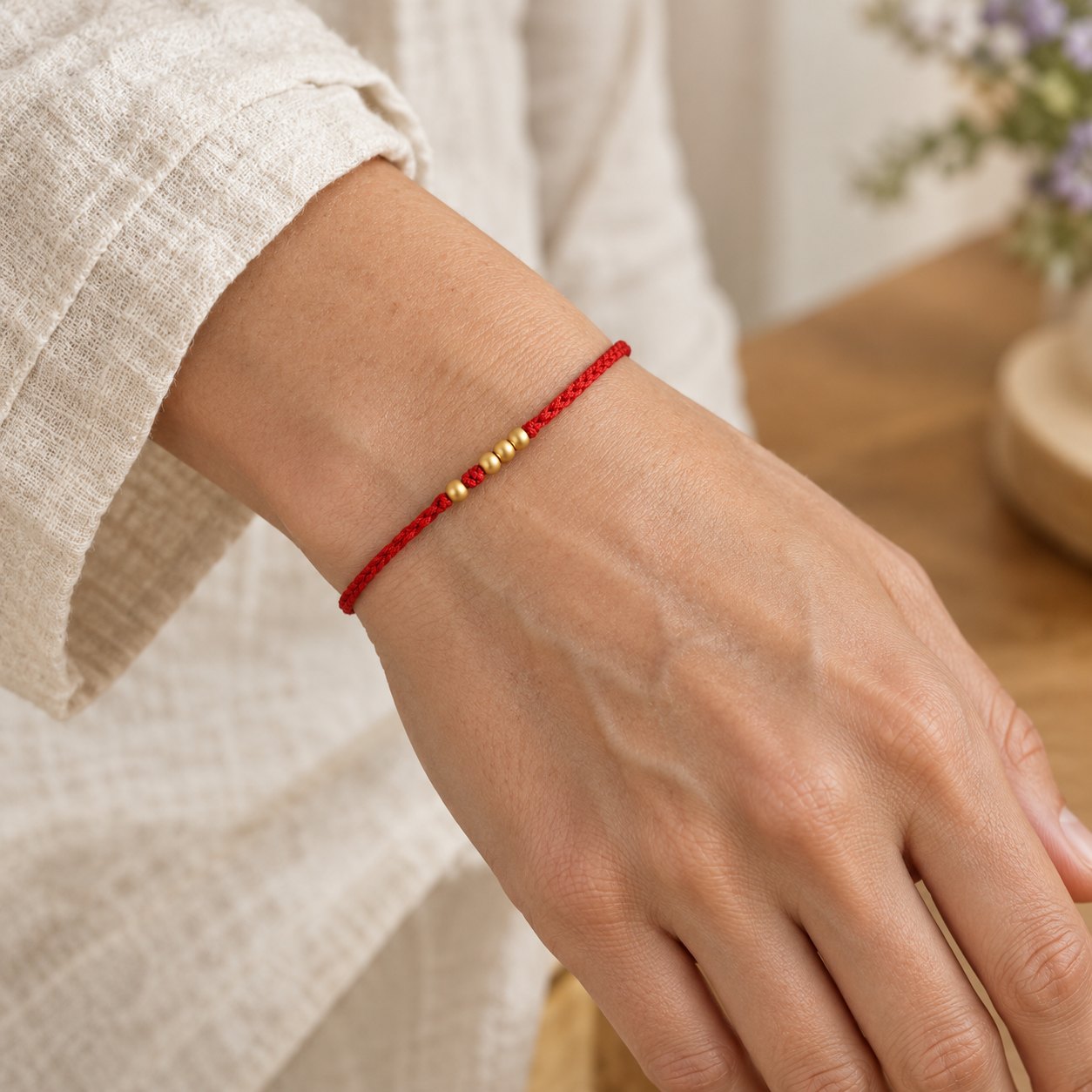 999 Gold Beads Red String Protection Bracelet for Couples, worn on the wrist by a woman