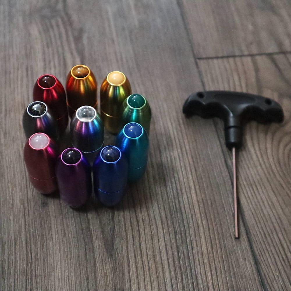 Colorful aluminum keycaps and keycap puller tool in a circular arrangement