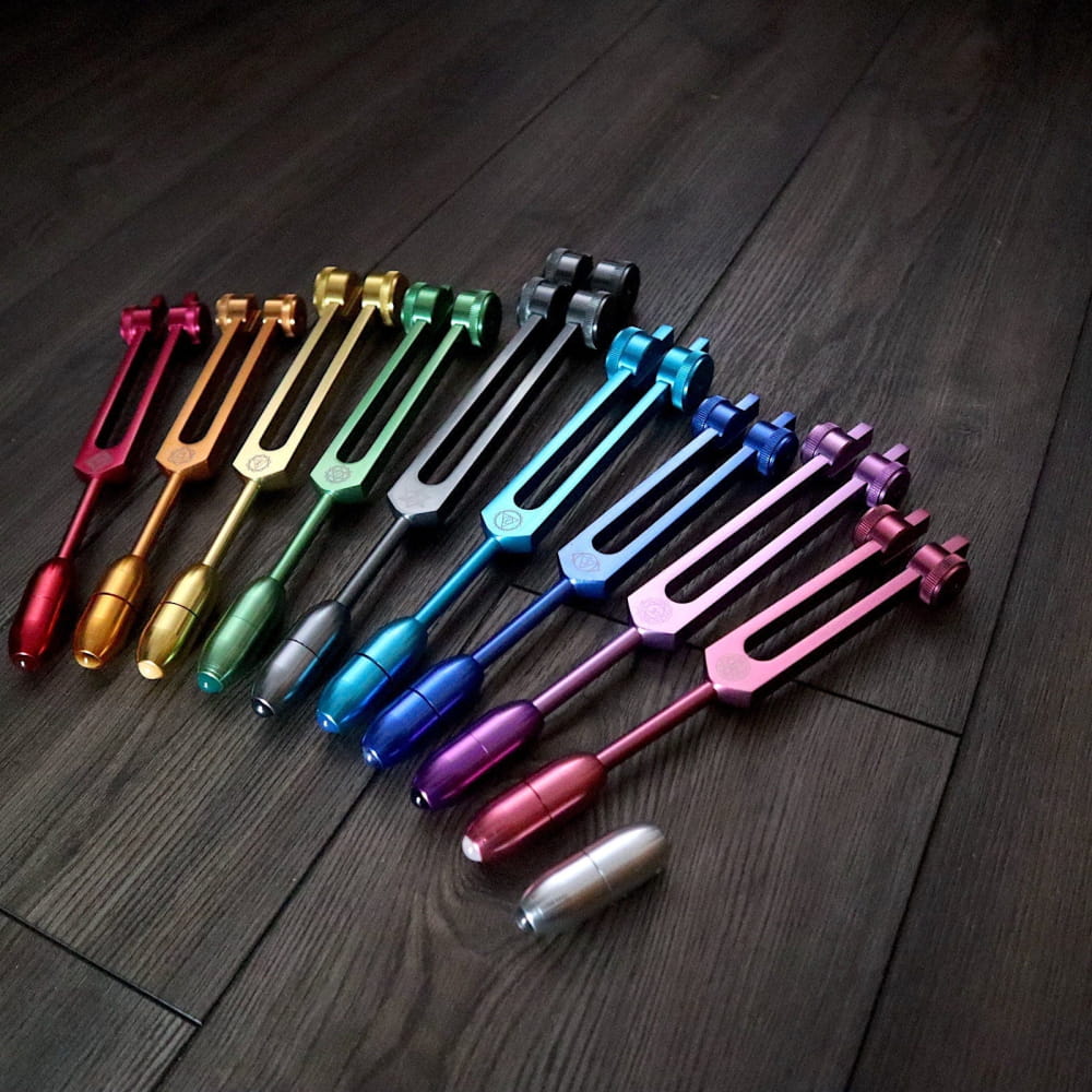 Rainbow-colored tuning forks in curved line for 9pc Chakra Tuning Forks Set