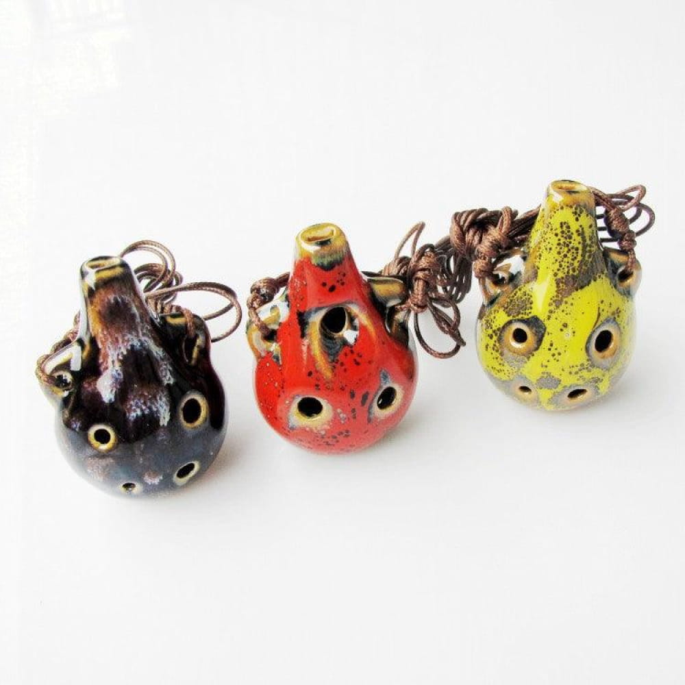 Black, red, and yellow ceramic ocarina pendants with decorative dots for beginners