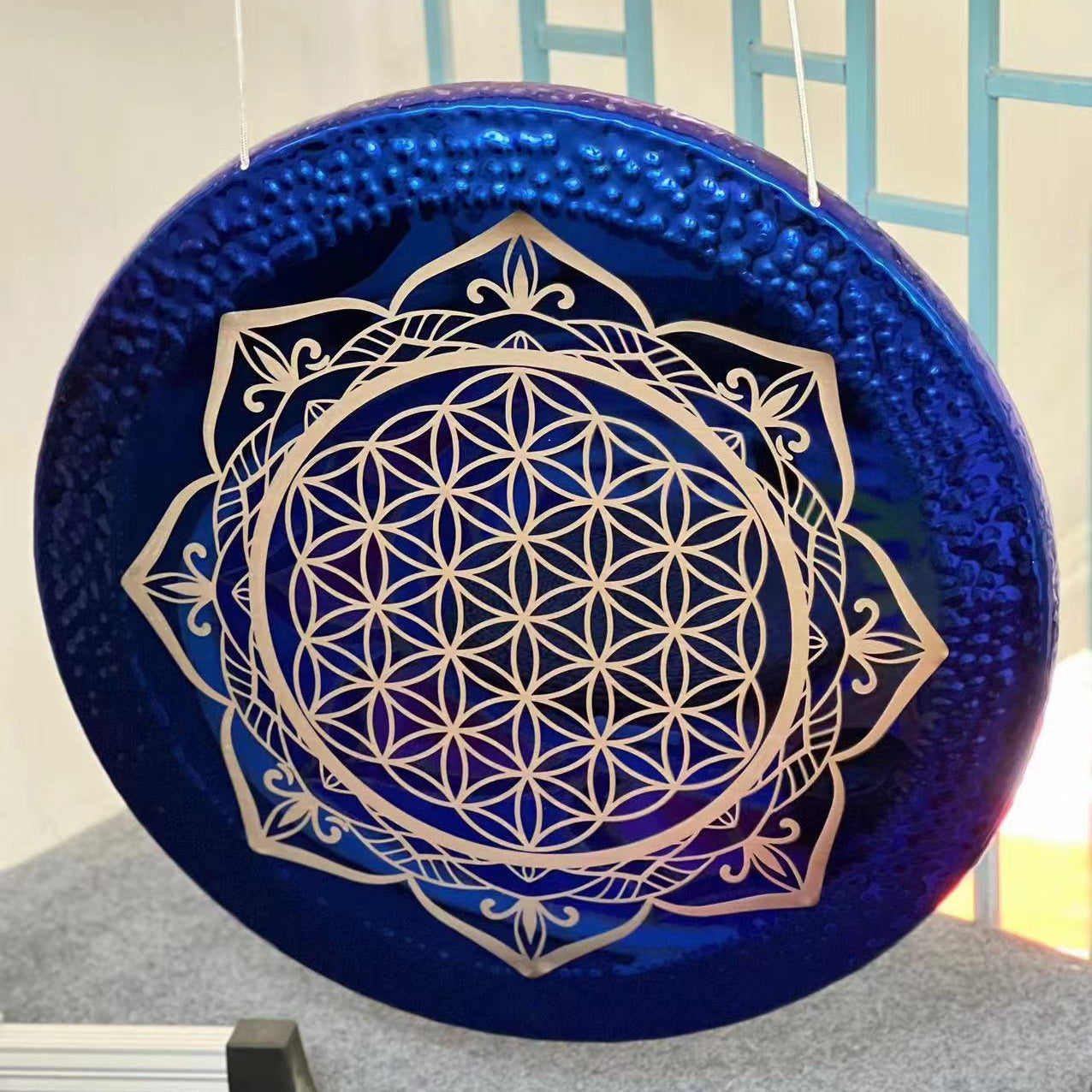Circular blue drum with silver Flower of Life mandala design for sound healing