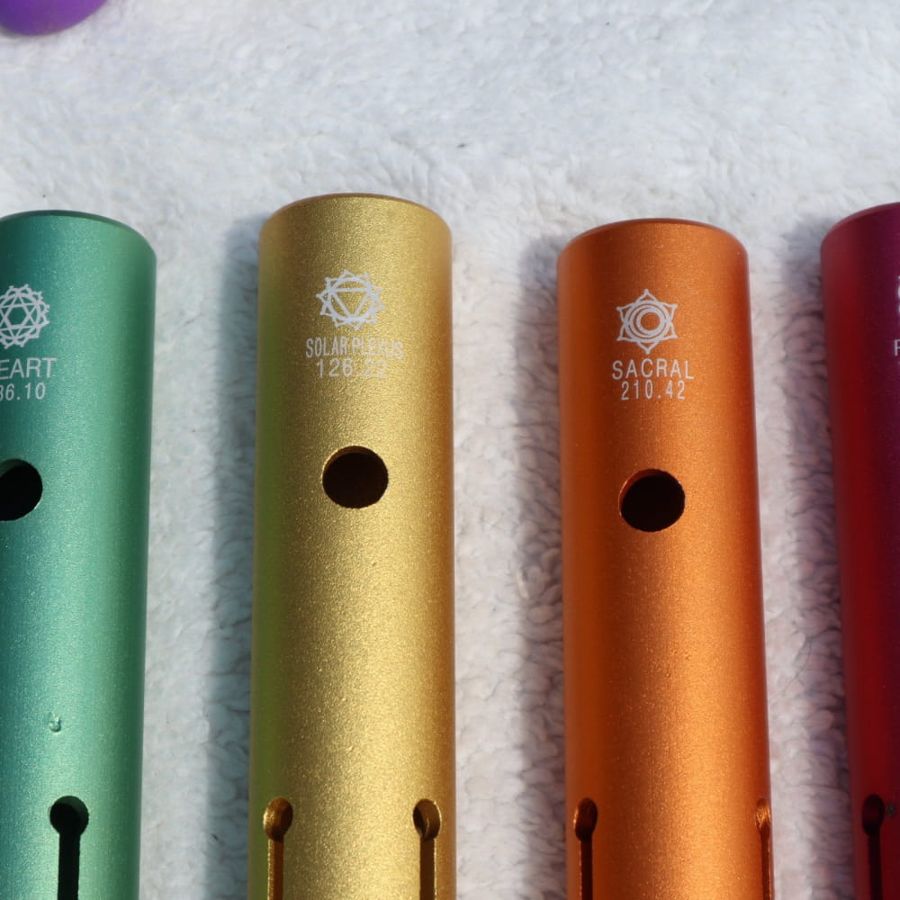 Colorful metal flutes arranged for Complete Chakra Solfeggio Tubes healing product