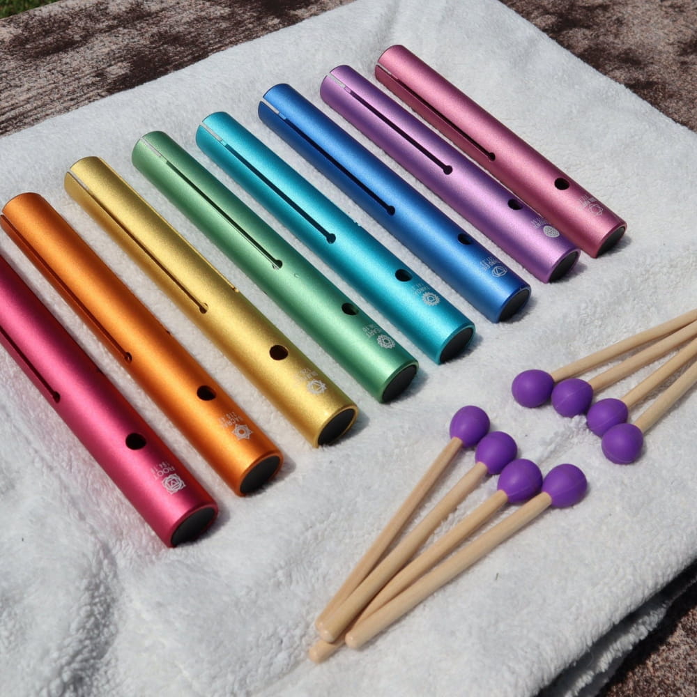 Rainbow metal tubes with holes and purple-tipped mallets in Complete Chakra Solfeggio Tubes