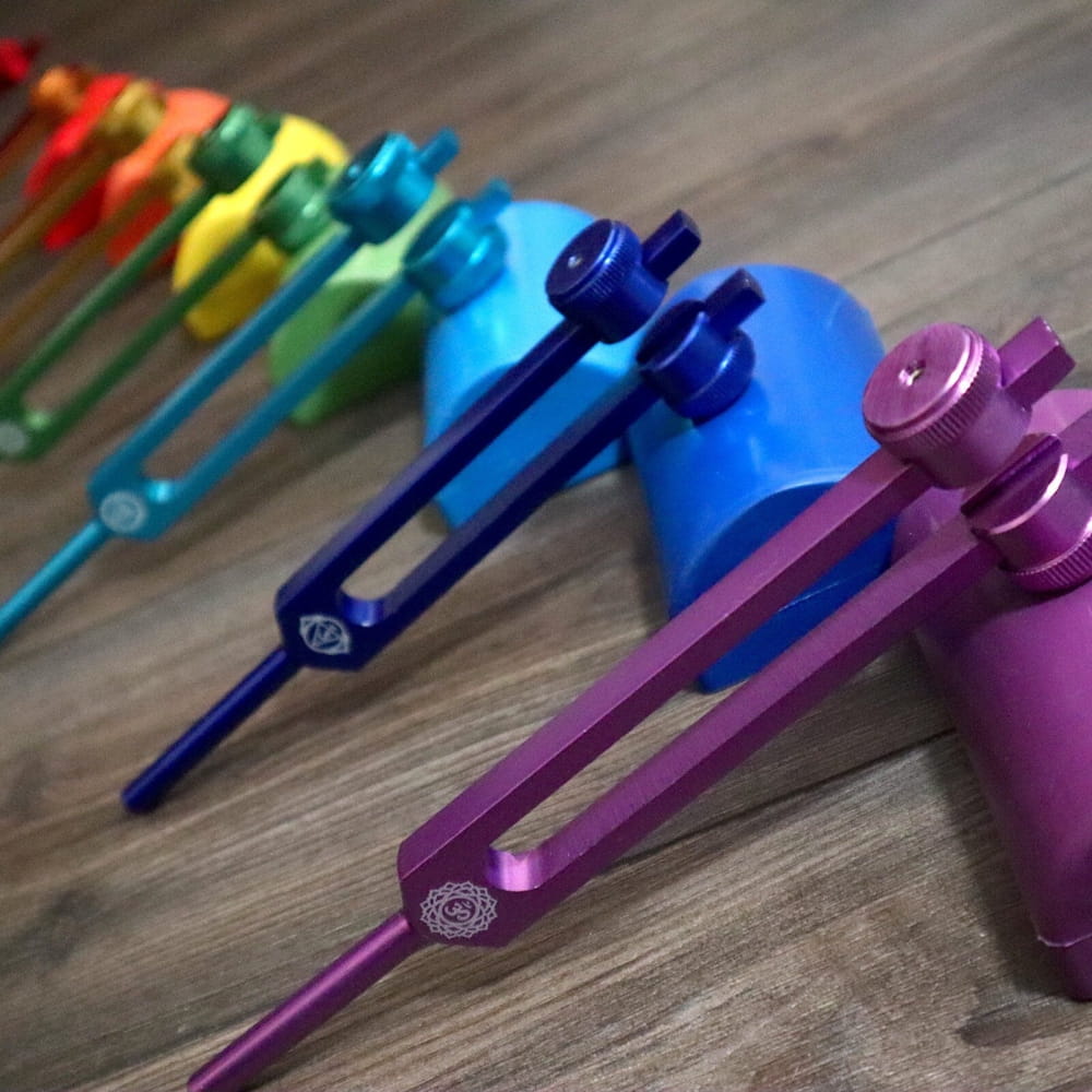 Rainbow-colored Healing Tuning Fork Activators arranged in a curved line