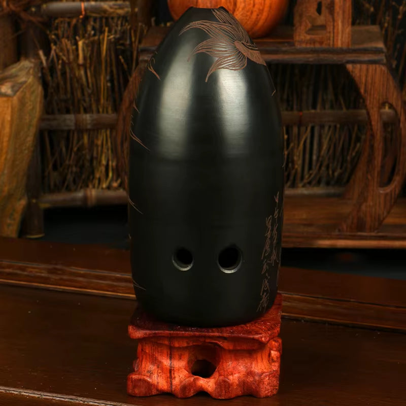 Black medieval-style helmet with eye holes on red wooden base for 10-Hole Ceramic Xun F Key