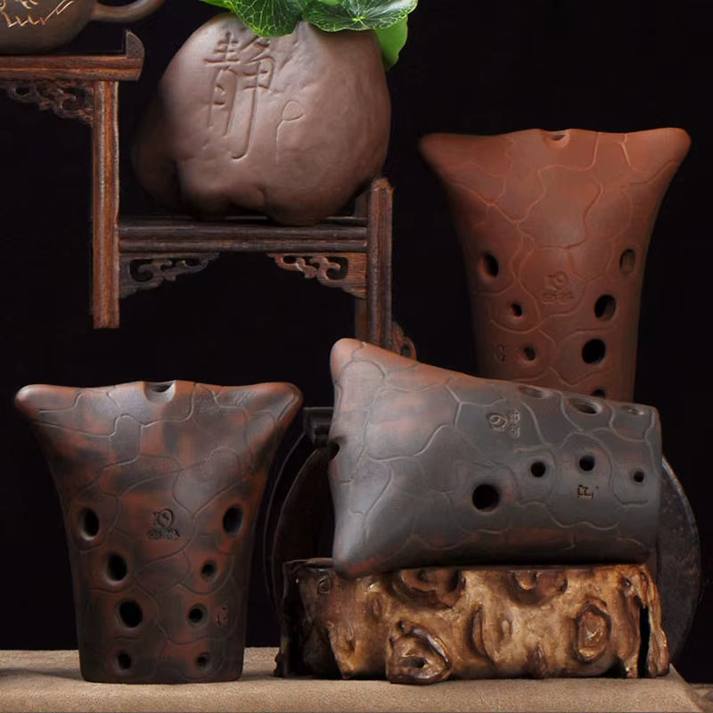 Clay Chinese Xun musical instrument with decorative holes in artistic patterns