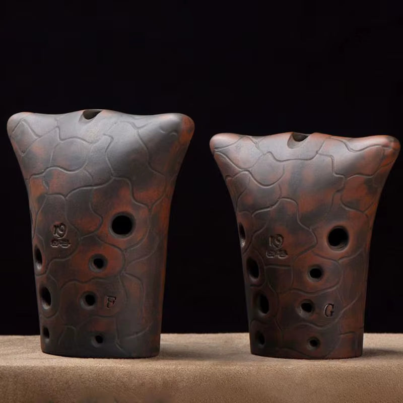 Two textured clay ocarina flutes with finger holes for the Xun musical instrument