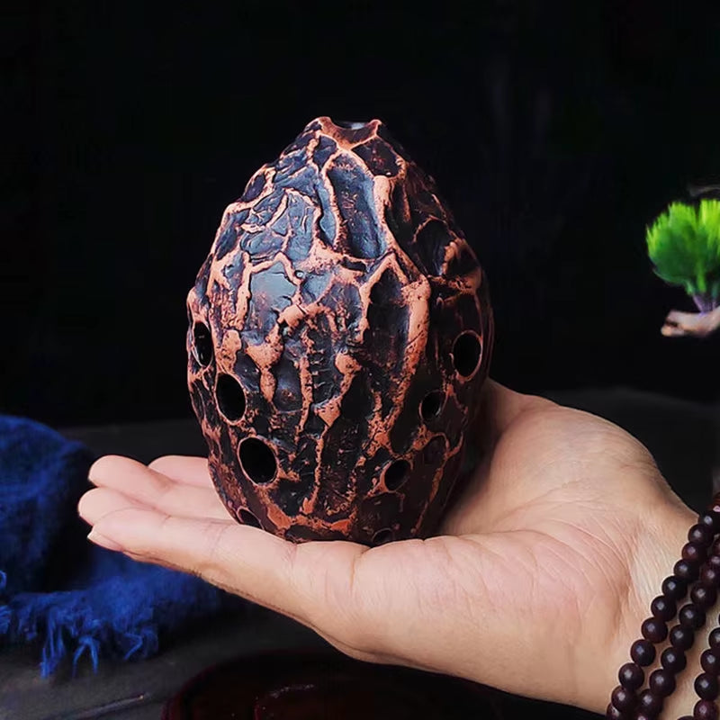 Textured copper-colored egg with web-like patterns on 10-Hole Pottery Xun instrument