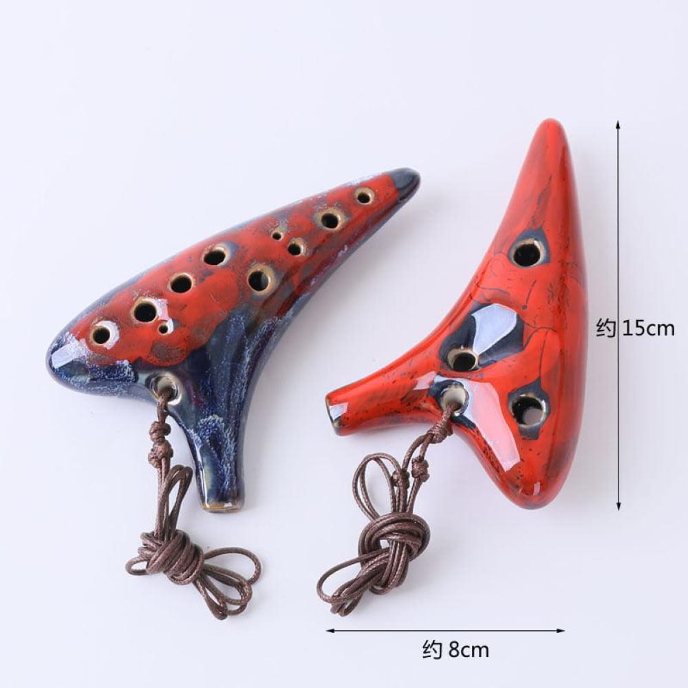 Two red ceramic ocarinas with finger holes and decorative cords in 12 Hole Alto C Metal Style