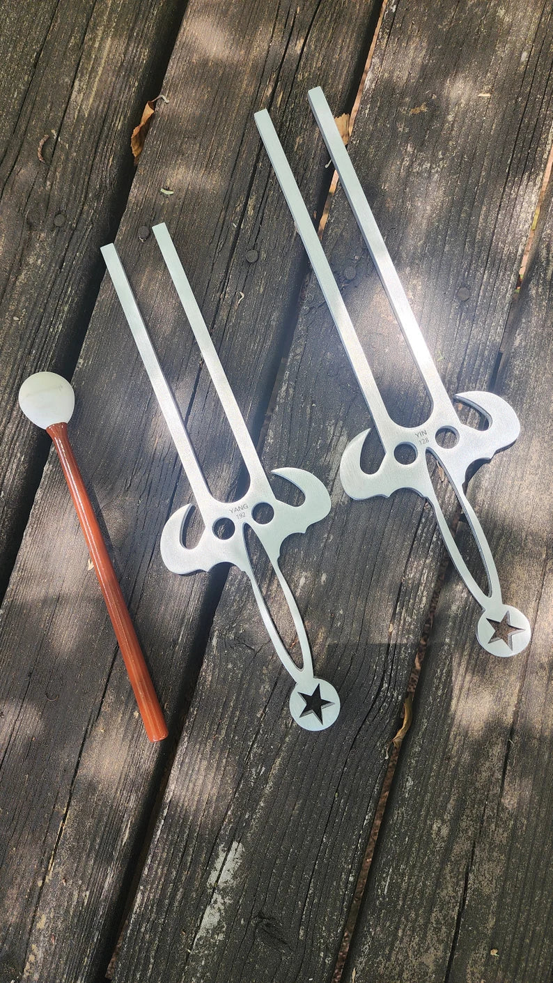 Two large Yin Yang tuning forks made of metal or plastic in decorative design