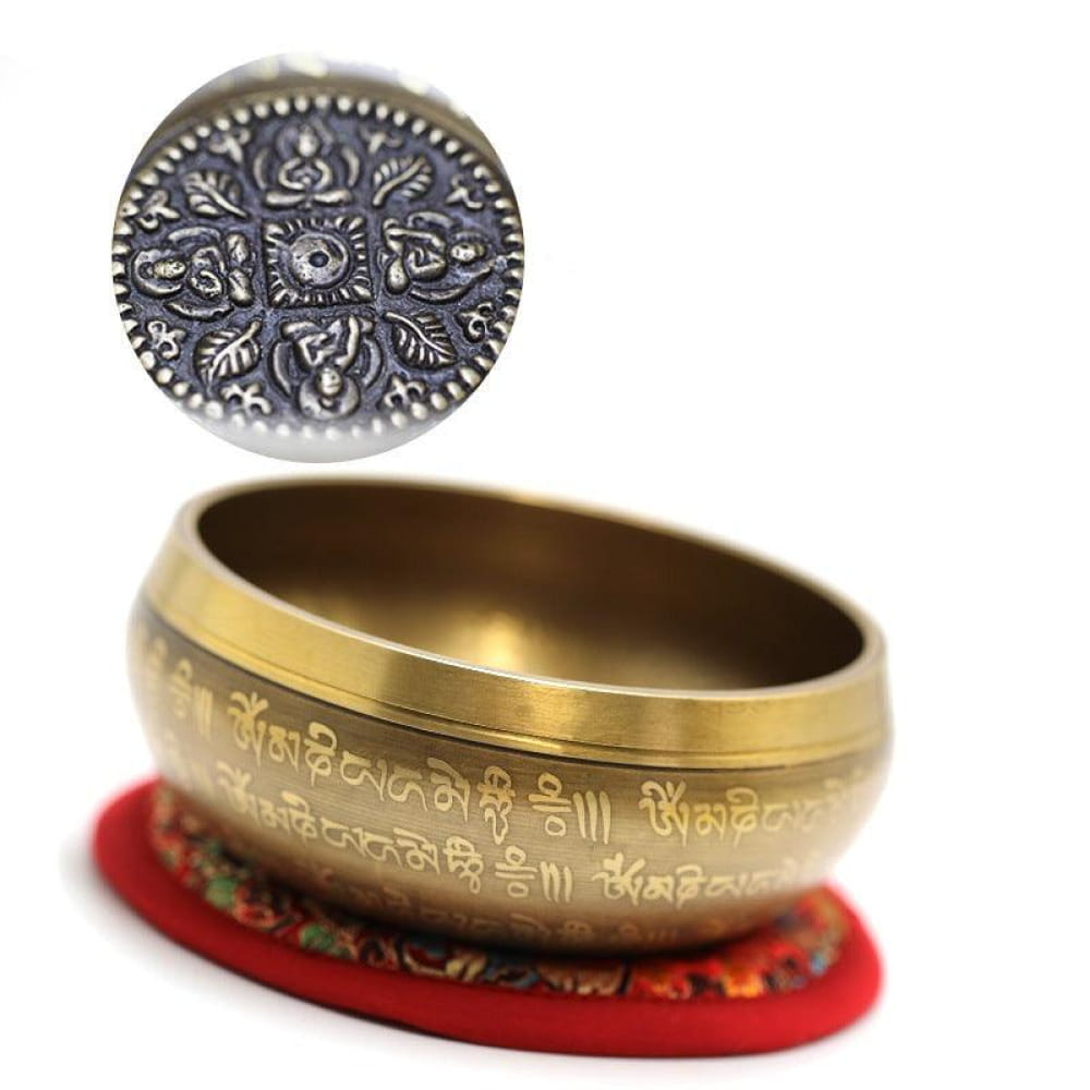 Tibetan singing bowl with Sanskrit engraving on red cushion for meditation purposes