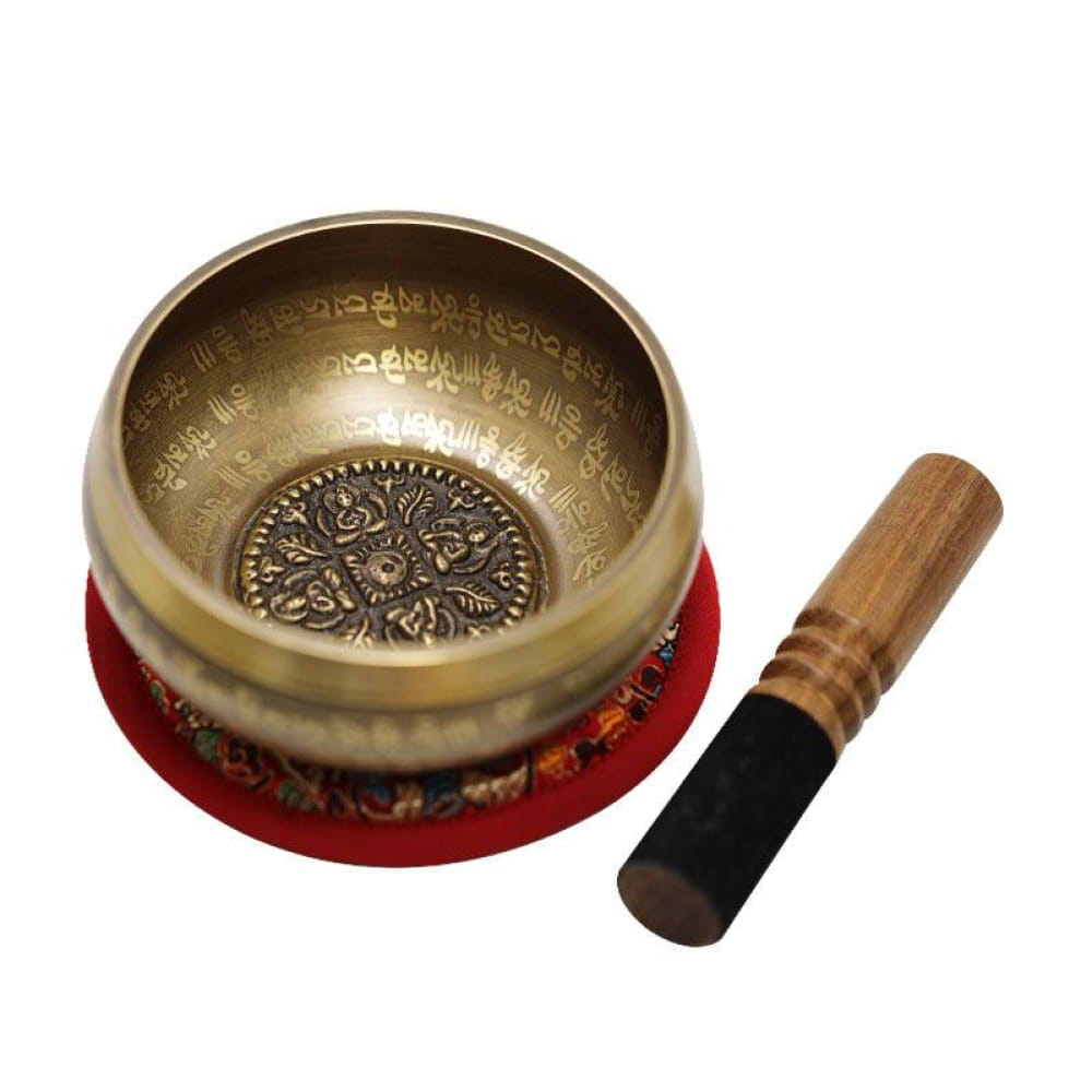 Tibetan singing bowl with striker on red cushion for meditation and sound therapy