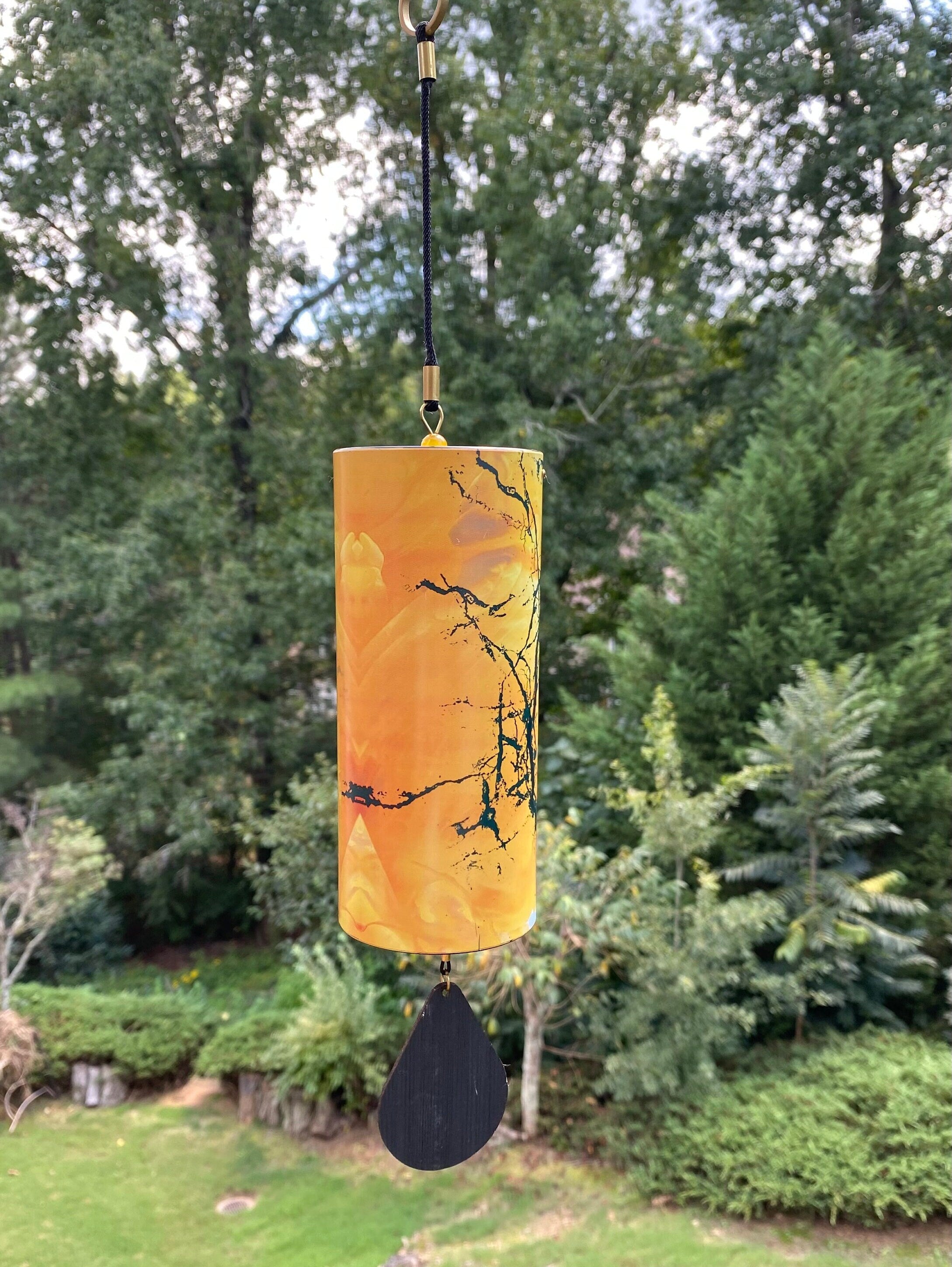 Cylindrical orange lantern with tree branch and bird silhouettes for home and garden decor