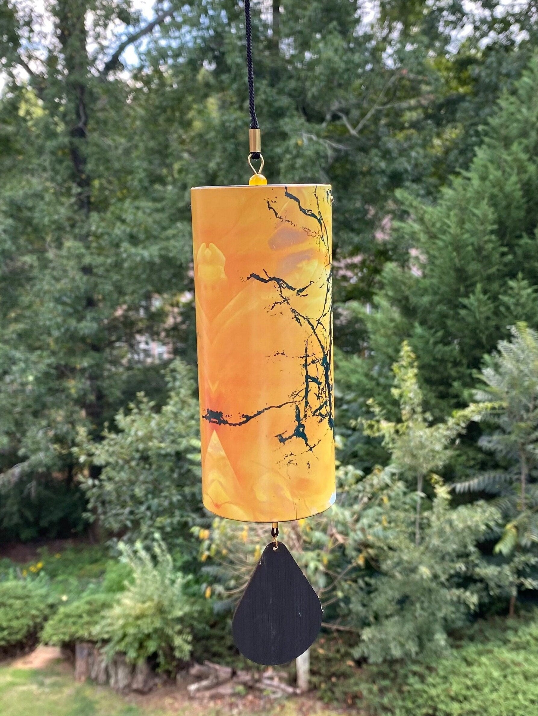 Orange wind chime with branch designs and dark pendant for home and garden décor