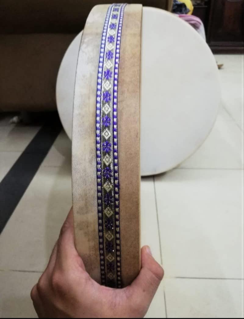 Decorative blue and white geometric ribbon on 16 Ocean Drum Instrument with Wave Beads