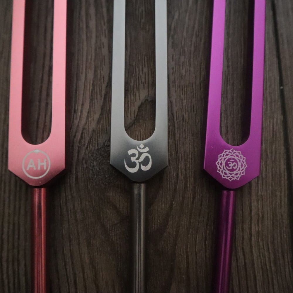 Three colorful tuning forks with spiritual symbols for Biofield Healing Therapy