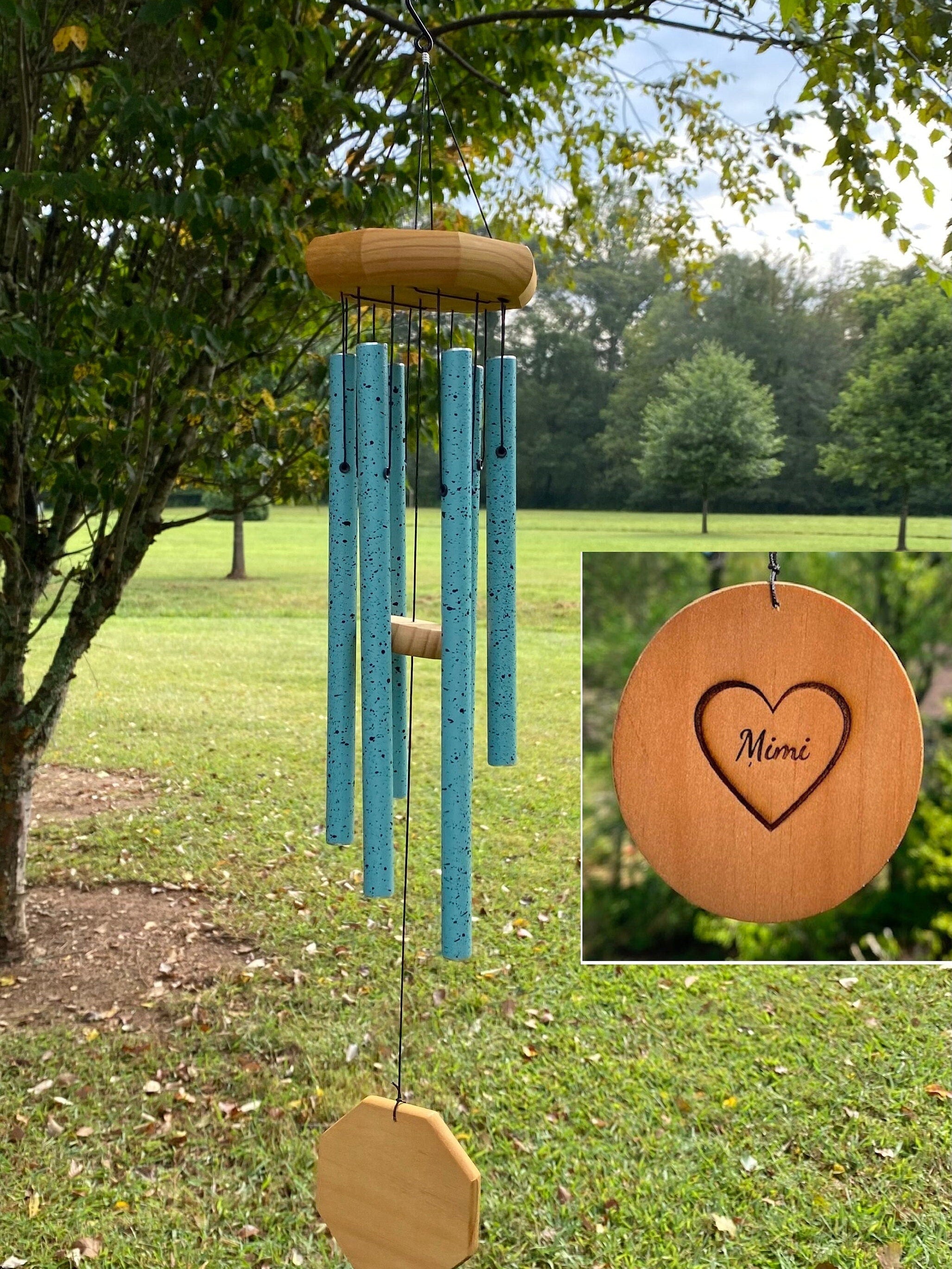 Turquoise wind chimes with wooden accents in a serene garden setting