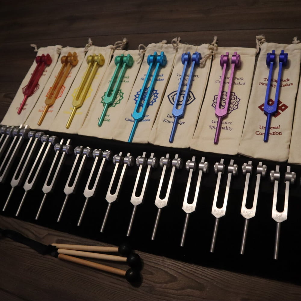 Colorful and silver tuning forks arranged for sound healing in rainbow sequence