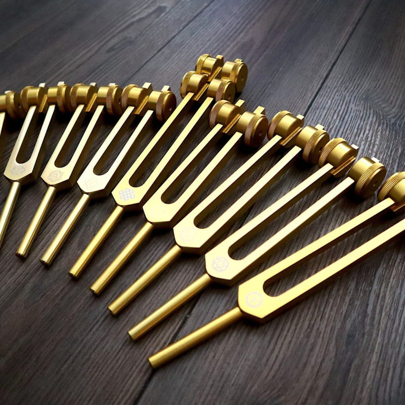 Golden tuning forks arranged in a row from 24pc Solfeggio Tuning Fork Set for Sound Healing