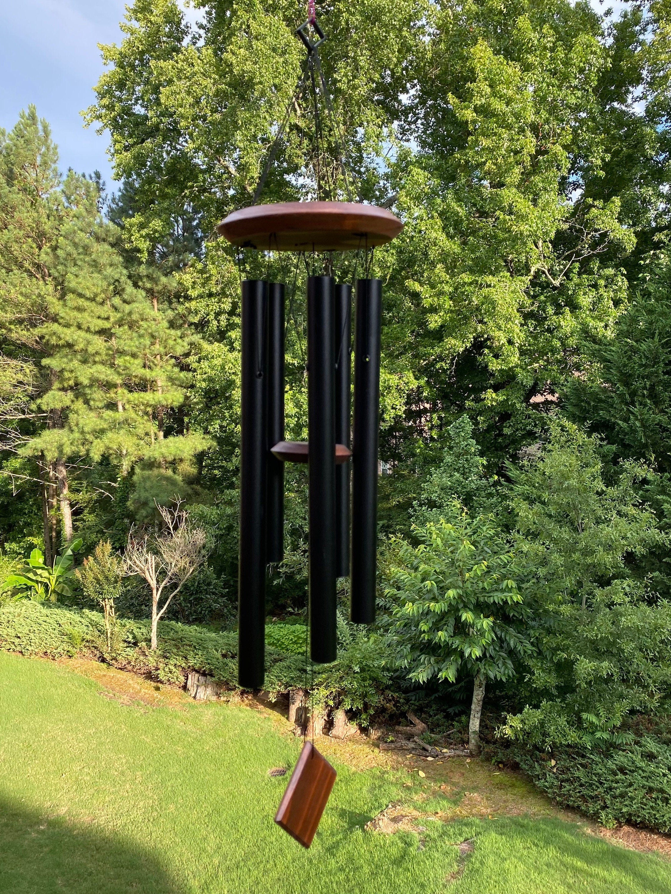 Black metal wind chime with reddish-brown top, perfect for outdoor serenity decor