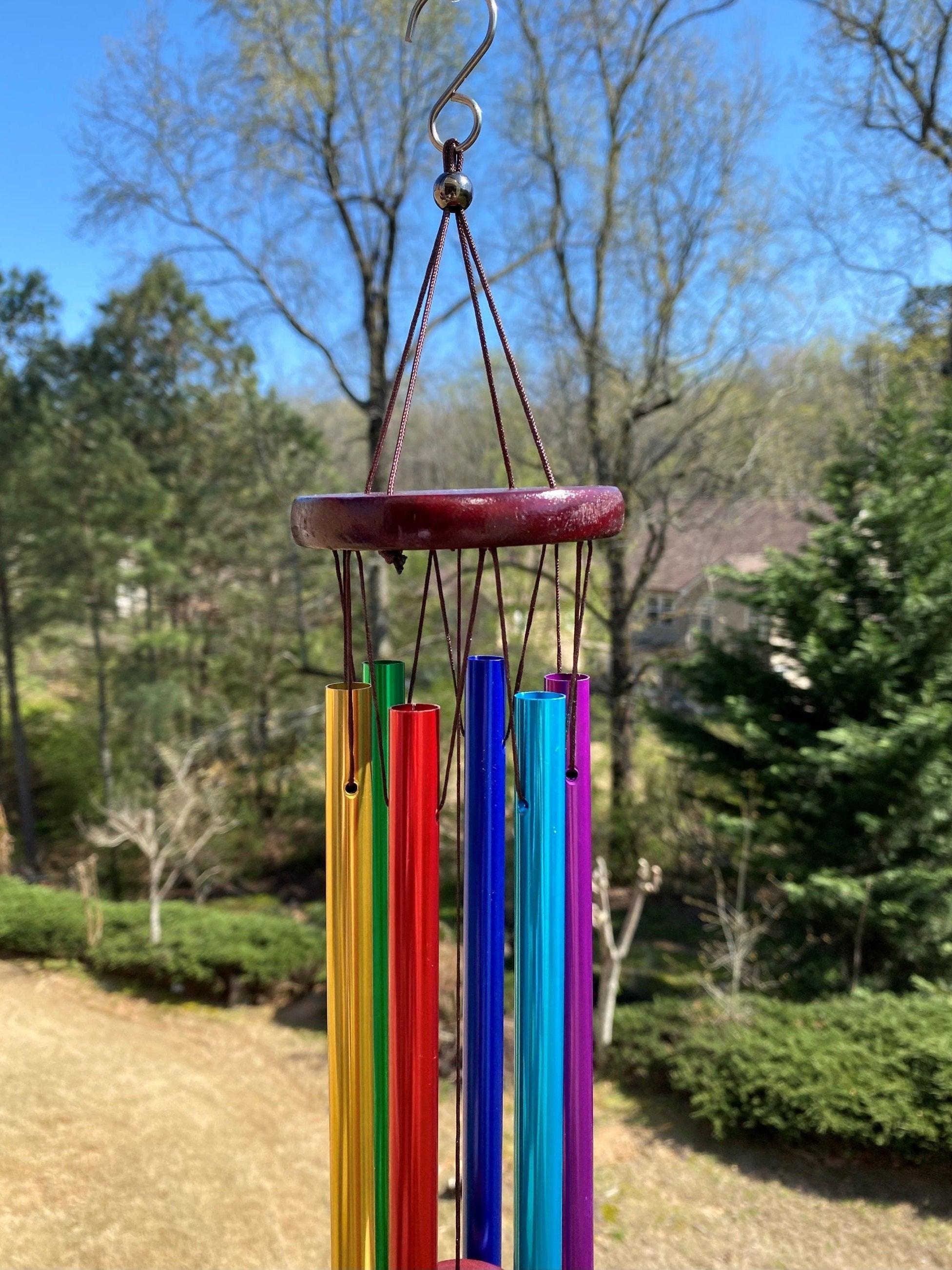 Colorful glass wind chimes with rainbow tubes hanging from a wooden top for decor