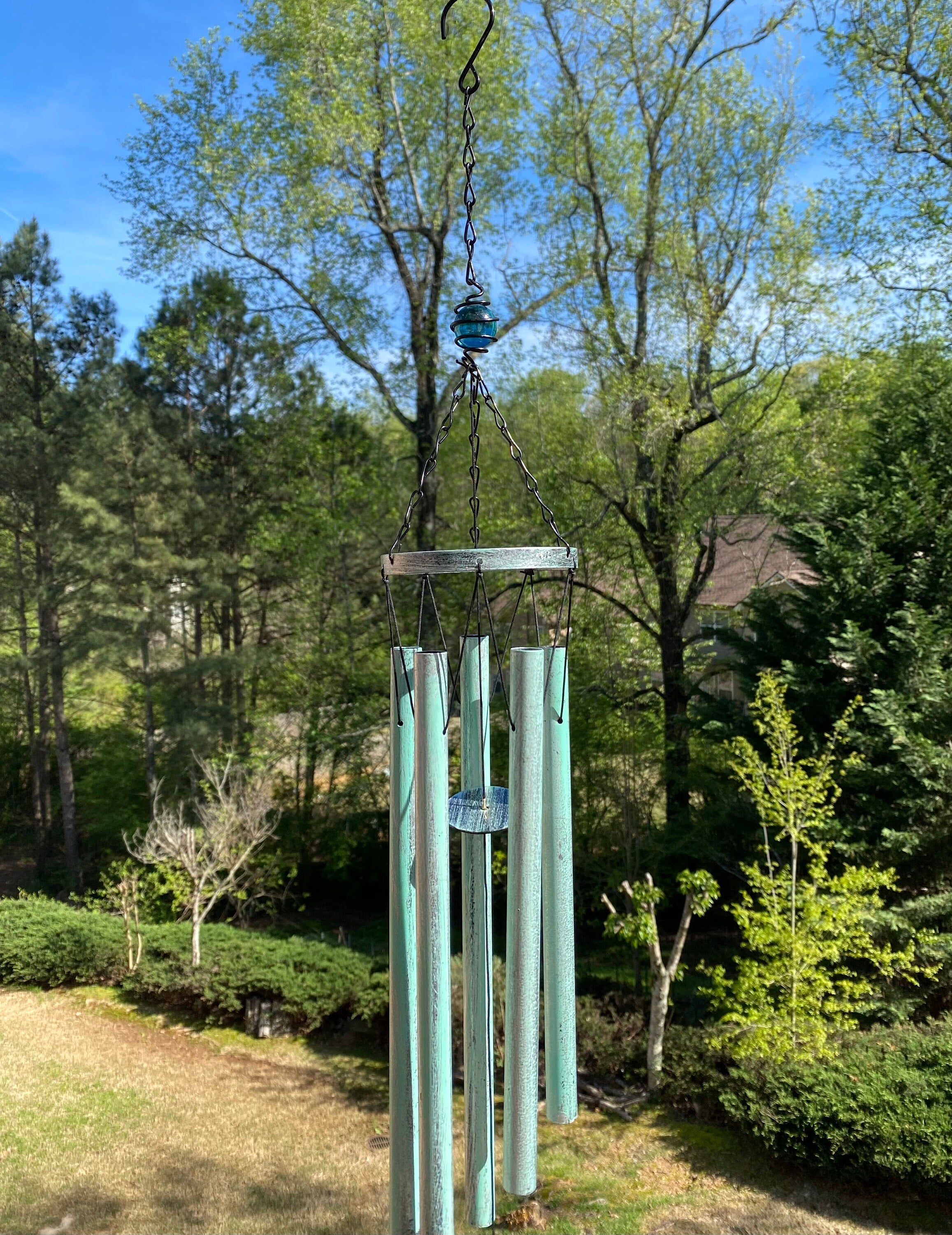 Turquoise wind chimes hanging from a metal hook, 31’’ deep tone decorative item