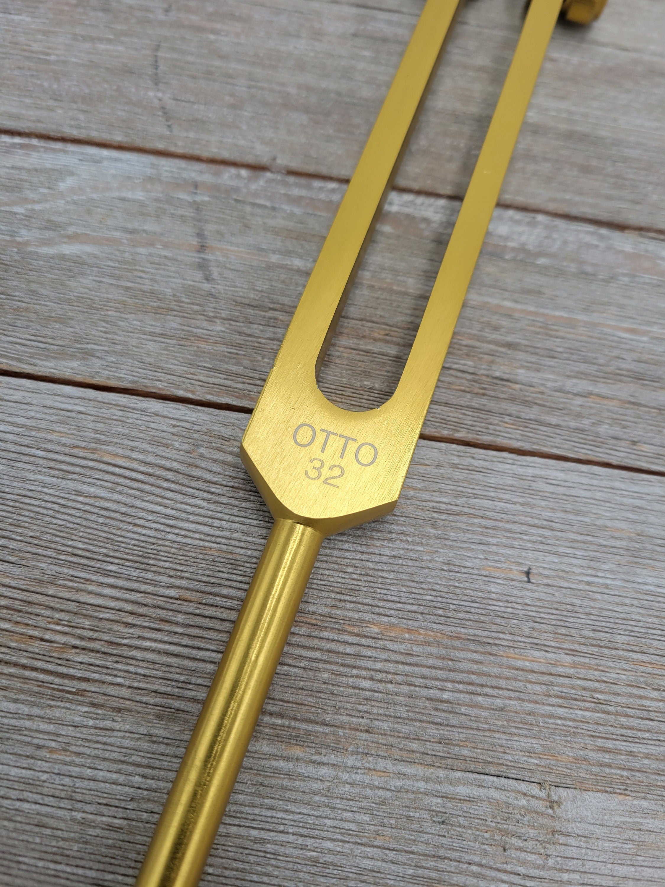 Golden tuning fork engraved with OTTO for 32 Hz healing and sound therapy