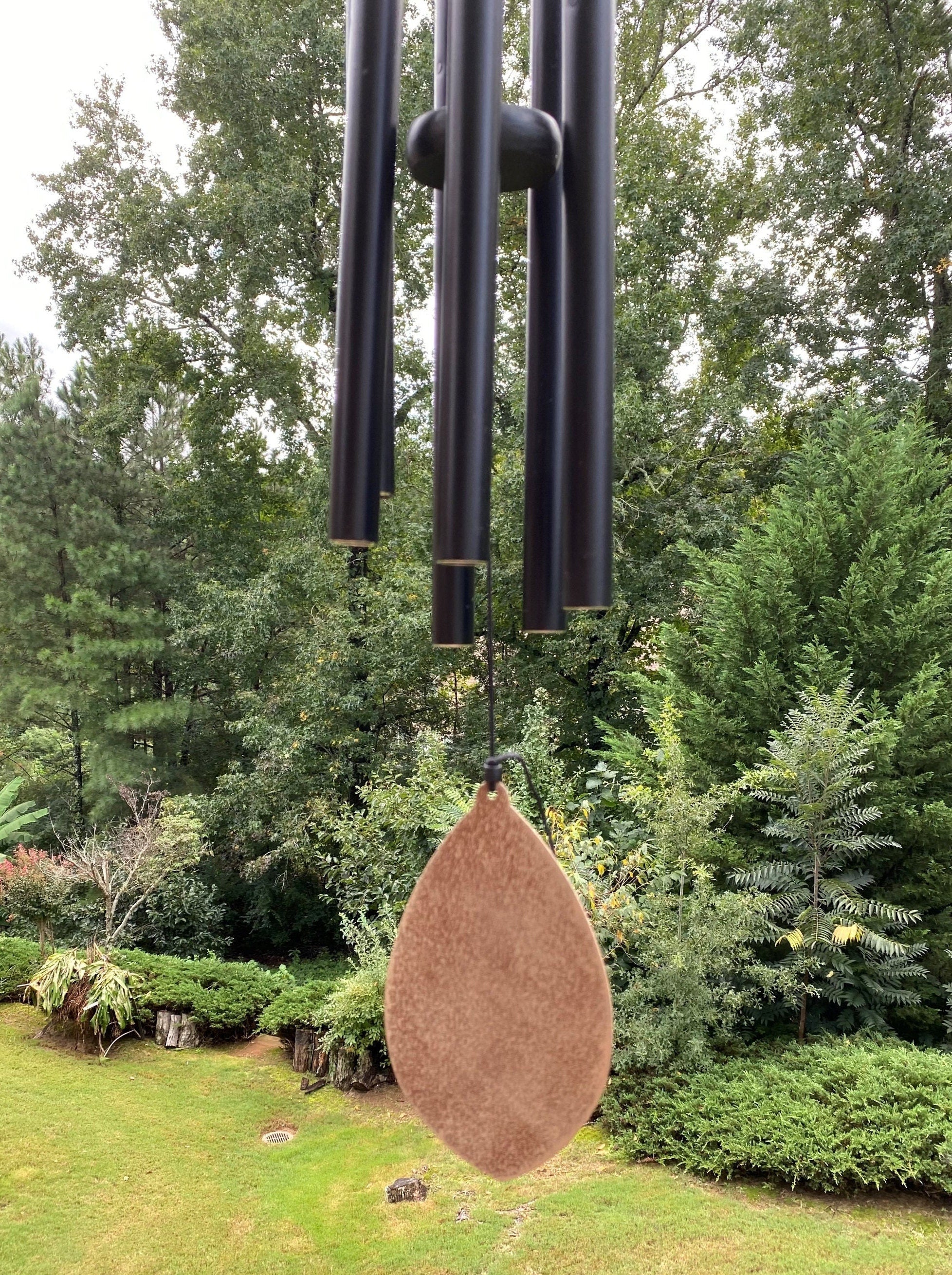 Wind chimes with black metal tubes and copper teardrop striker in a deep tone design