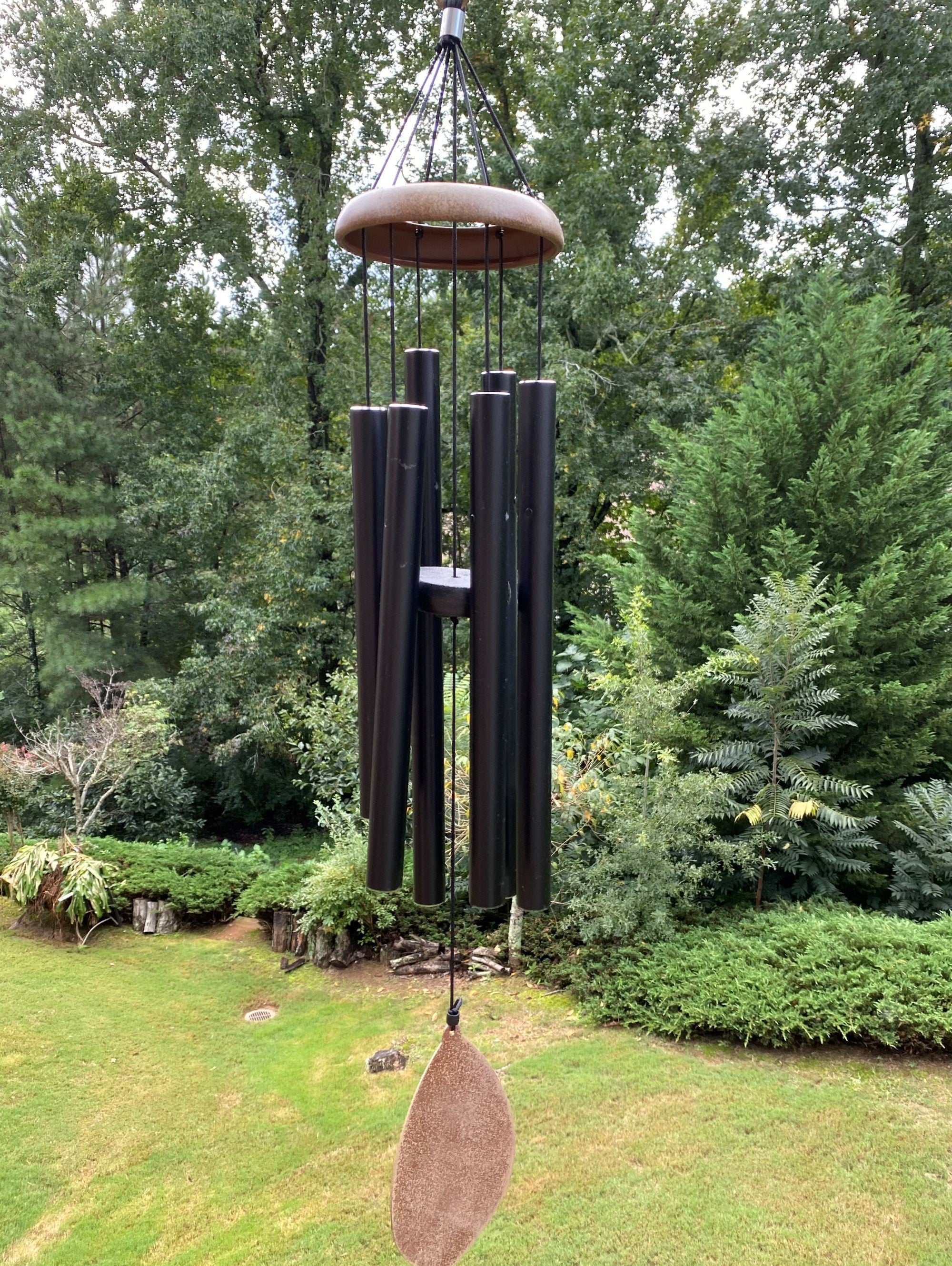 Wind chime with dark metal tubes and copper-colored dome top for memorial use