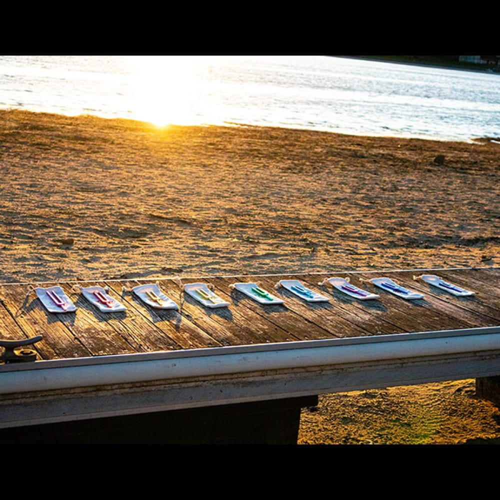 Row of surfboards on a wooden deck at sunset, enhancing harmony with Tuning Fork Set