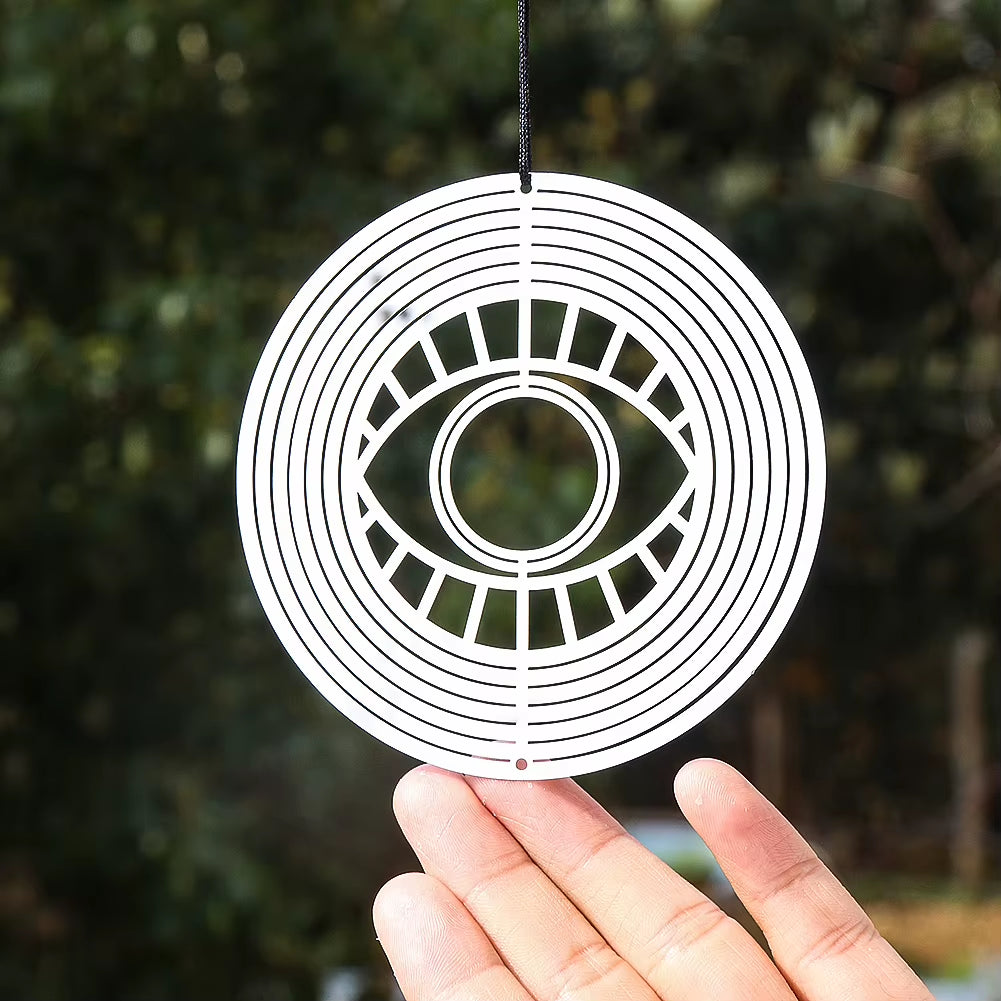 White circular wind spinner featuring an eye design in the center for outdoor decor