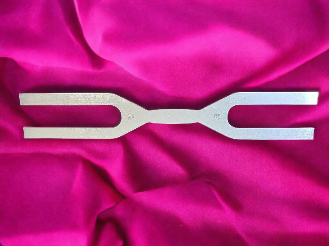 Metal tuning fork on pink fabric from 432 Hz & 288 Hz Healing Tuning Fork Set