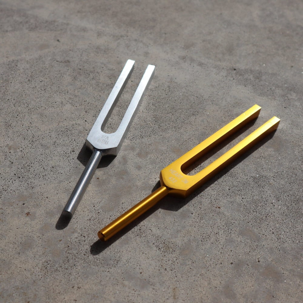 Two tuning forks in silver and gold for 432 Hz and 528 Hz vibration therapy