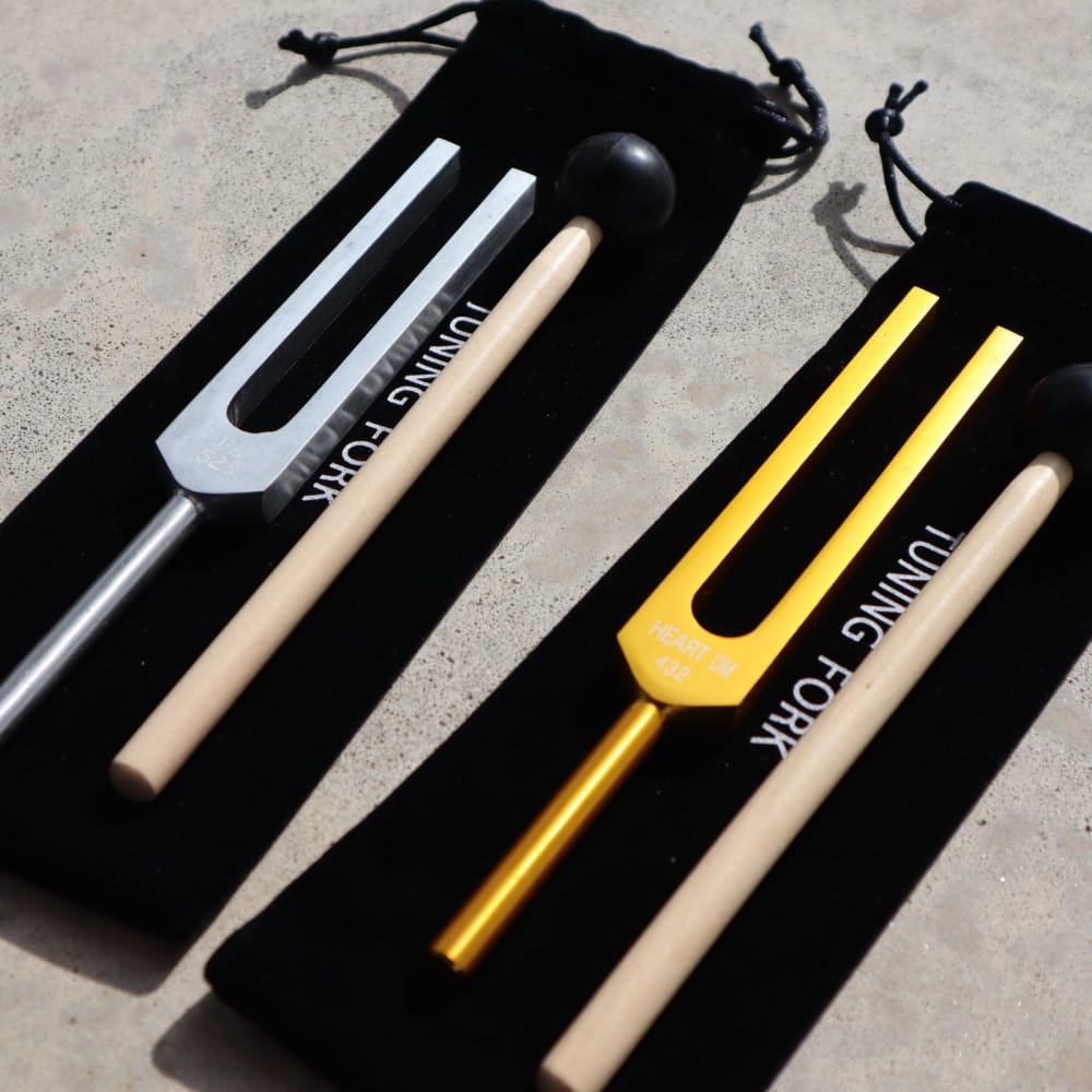 Two tuning forks in black velvet pouches for 432 Hz and 528 Hz vibration therapy