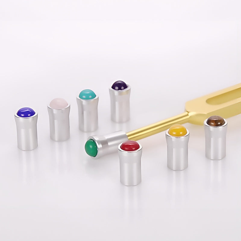 Metallic tuning forks with colorful gemstones for healing and sound therapy