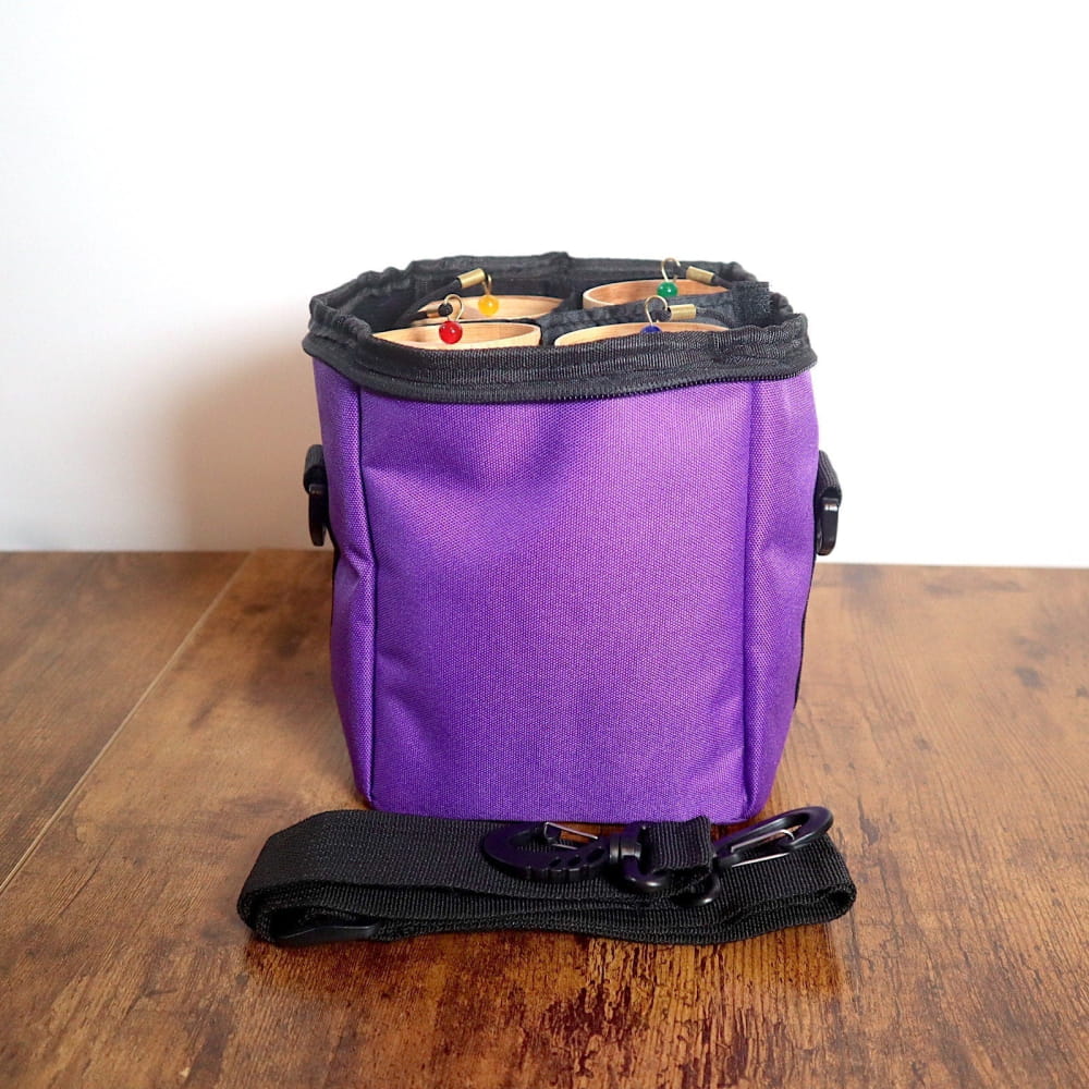 Purple fabric treat pouch with black trim and shoulder strap for easy access and portability